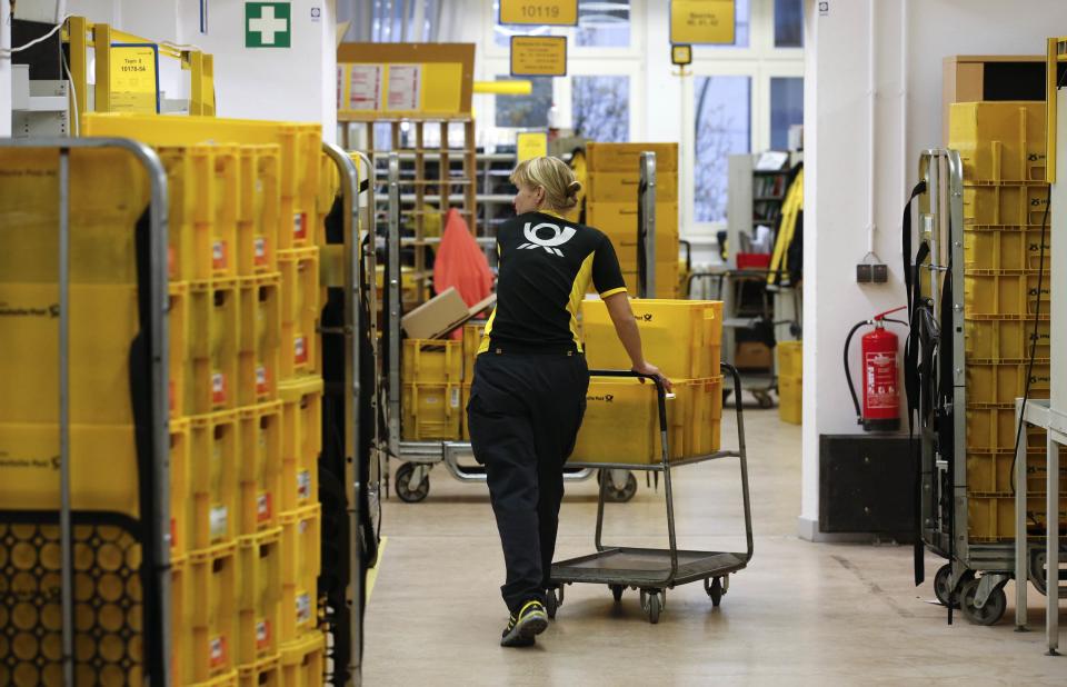 Sabine Standke, 32-year-old postwoman of the German postal and logistics group Deutsche Post, pushes a trolley with mail at a sorting office in Berlin's Mitte district, December 4, 2013. Deutsche Post, the world's number one postal and logistics group, transported around 18 billion letters in 2012. REUTERS/Fabrizio Bensch (GERMANY - Tags: BUSINESS EMPLOYMENT)