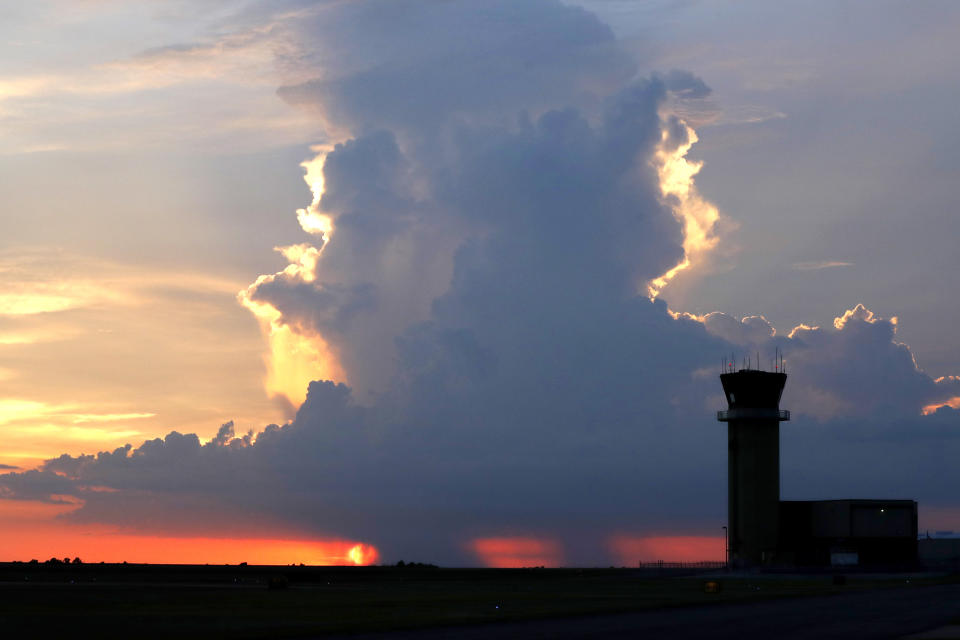 In this July 15, 2018 photo, the New Orleans Lakefront Airport air traffic control tower is seen in front of a sunset and a rain cloud over Lake Pontchartrain, in New Orleans. The Department of Homeland Security plans to issue a security alert Tuesday for small planes, warning that modern flight systems are vulnerable to hacking if someone manages to gain physical access to the aircraft. A DHS alert recommends that plane owners ensure they restrict unauthorized physical access to their aircraft until the industry develops safeguards to address the issue, which was discovered by Boston-based cybersecurity company, Rapid7, and reported to the federal government. (AP Photo/Gerald Herbert)