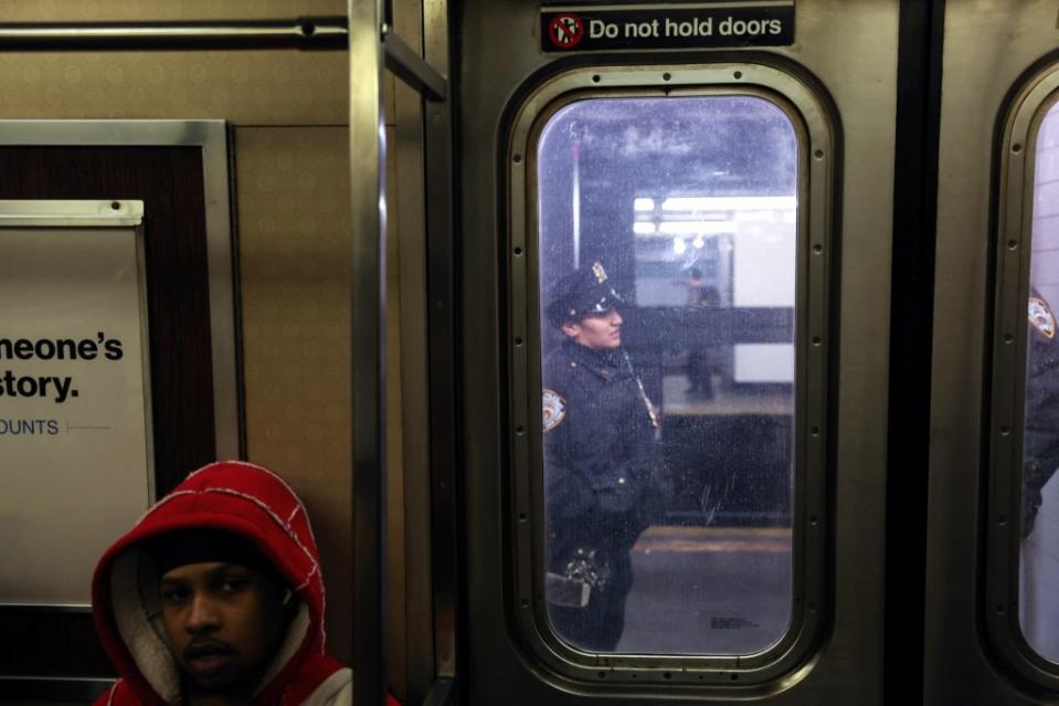 A rider sits inside the train as NYPD patrol the subway platform at the Hoyt-Schermerhorn station in Brooklyn on March 15, 2024. The scene unfolded just hours after one man was left shot and badly injured after he lost his gun amid a fight aboard a train. REUTERS