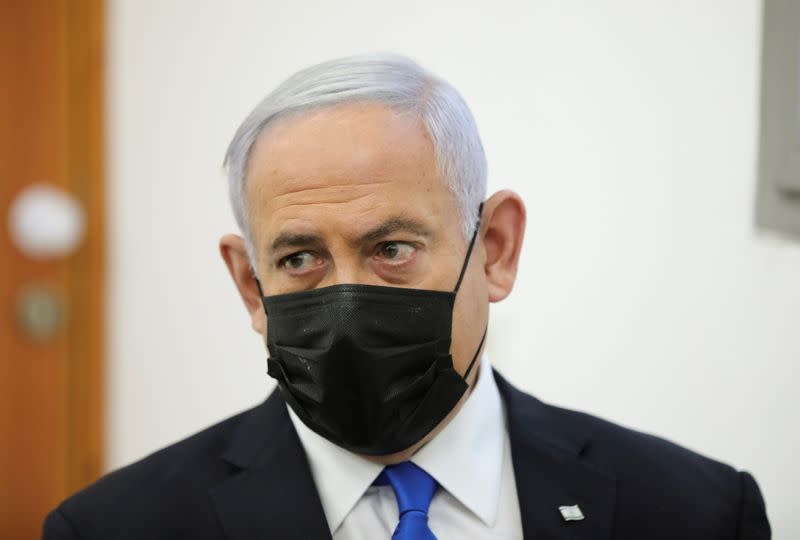 Israeli Prime Minister Benjamin Netanyahu, wearing a face mask, looks on as his corruption trial resumes, at Jerusalem's District Court