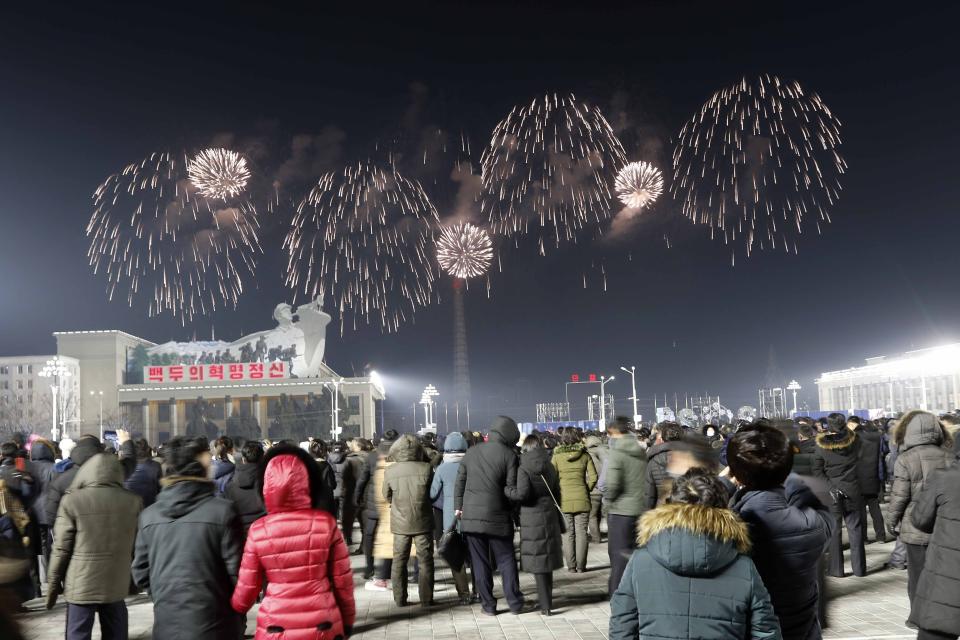 A fireworks display decorates the night sky to celebrate the New Year, as crowds of people look on, at Kim Il Sung Square in Pyongyang, North Korea, early Friday, Jan., 1, 2021. (AP Photo/Jon Chol Jin)