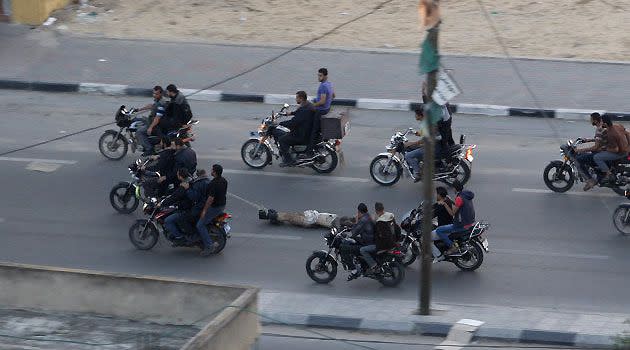 Palestinian gunmen ride motorcycles as they drag the body of a suspected collaborator with Israel.