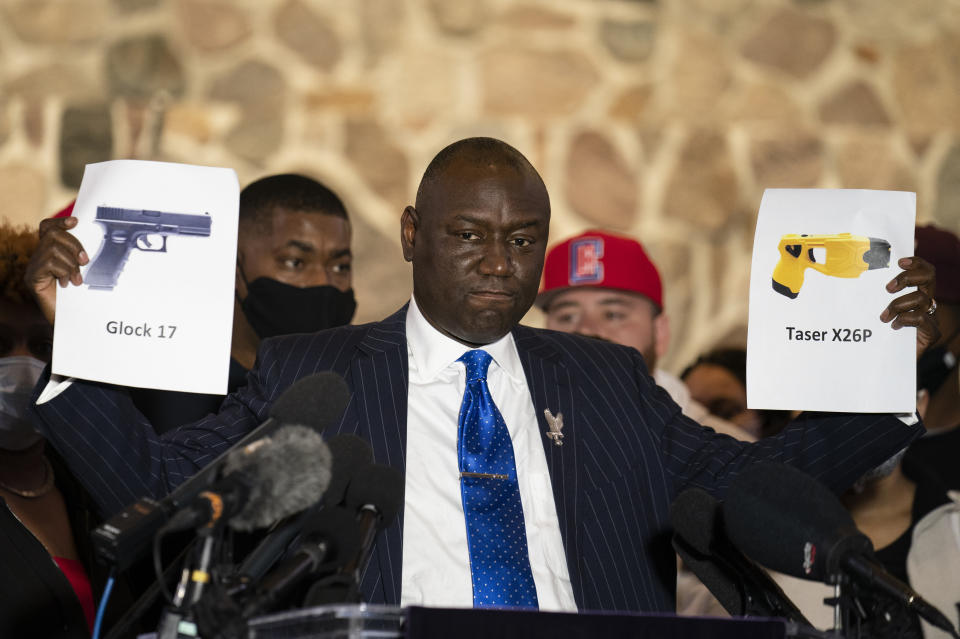 FILE - Attorney Ben Crump, representing the family of Daunte Wright, holds up images depicting X26P Taser and a Glock 17 handgun during a news conference at New Salem Missionary Baptist Church, April 15, 2021, in Minneapolis. (AP Photo/John Minchillo, File)