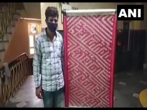 Cot weaver Shravan shows a cot made by him with an awareness message. [Photo/ANI] 