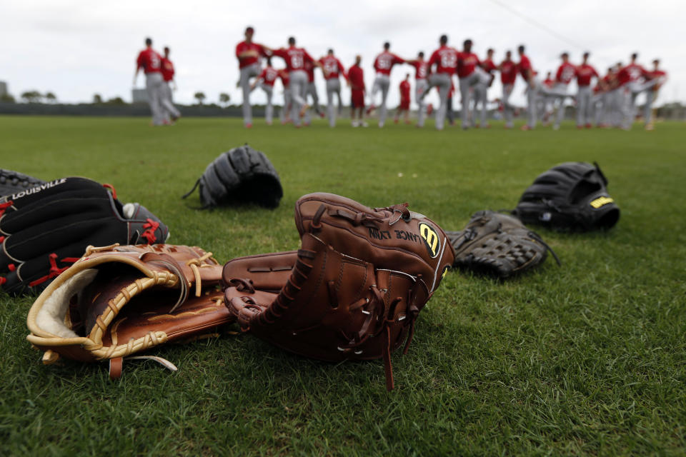 Members of the St. Louis Cardinals warm up at the start of the first official spring training baseball practice for the team's pitchers and catchers Thursday, Feb. 13, 2014, in Jupiter, Fla. (AP Photo/Jeff Roberson)