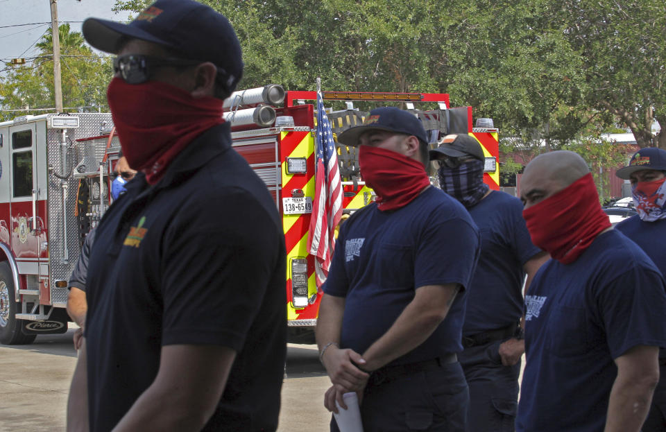 McAllen Fire Department firefighters listen quietly as three brothers play a cello concerto to celebrate the firemen during the coronavirus pandemic Wednesday, May 20, 2020, in McAllen, Texas. (Delcia Lopez/The Monitor via AP)