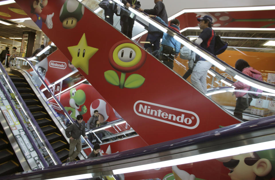 FILE - In this Sunday, Dec. 15, 2013 file photo, shoppers take escalators painted with the logo of Nintendo and Super Mario characters at an electronics store in Tokyo. Nintendo Co. says its profit for the first nine months of the fiscal year fell 30 percent because of languishing sales of its Wii U home consoles and game software. The Japanese maker of Super Mario video games reported Wednesday, Jan. 29, 2014, a 10.2 billion yen ($99 million) profit from April to December, down from 14.55 billion yen a year earlier. It did not break down quarterly numbers. (AP Photo/Shizuo Kambayashi, File)