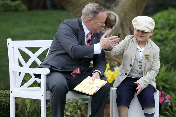 WASHINGTON, DC - APRIL 17:  White House Press Secretary Sean Spicer gives a high-five to a boy who sat next to him while he read the childrens' book 'How To Catch The Easter Bunny' during the 139th Easter Egg Roll on the South Lawn of the White House April 17, 2017 in Washington, DC. The White House said 21,000 people are expected to attend the annual tradition of rolling colored eggs down the White House lawn that was started by President Rutherford B. Hayes in 1878.  (Photo by Chip Somodevilla/Getty Images)