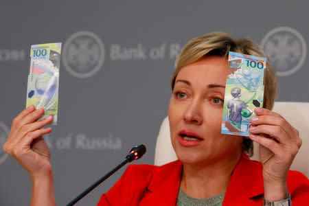 FILE PHOTO: Russian central bank deputy chairwoman Olga Skorobogatova holds the newly designed 100-rouble banknotes dedicated to the 2018 FIFA World Cup, during a news conference in Moscow, Russia May 22, 2018. REUTERS/Sergei Karpukhin/File Photo