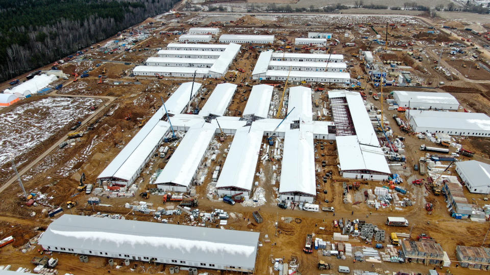 Workers erect a building which will be a new hospital, on the outskirts of Moscow, Russia, Thursday, April 2, 2020. The vast majority of Russian regions are currently on lockdown, ordering residents to self-isolate at home and not go out, unless it's to buy groceries, medications, walk their dogs or take out trash. For most people, the new coronavirus causes only mild or moderate symptoms. For some it can cause more severe illness. (Denis Voronin, Moscow News Agency photo via AP)