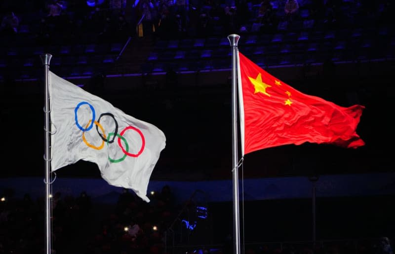 The flag of China and the Olympic flag flutter on their masts during the closing ceremony of the Beijing 2022 Winter Olympic Games at the Bird's Nest National Stadium. Twenty-three Chinese swimmers failed doping tests for the same banned substance ahead of the Tokyo Olympics in 2021 but several of them competed there after not being sanctioned by their country or international authorities. Michael Kappeler/dpa