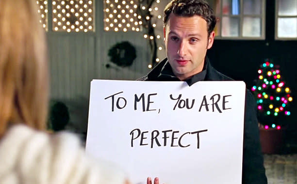 Still from Love Actually of Mark holding up a cue card that says "To me, you are perfect"