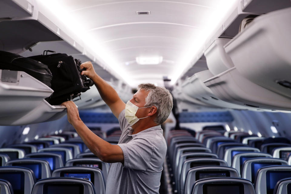 FILE - In this May 28, 2020, file photo, a passenger wears personal protective equipment on a Delta Airlines flight after landing at Minneapolis−Saint Paul International Airport in Minneapolis. Federal officials are extending into January a requirement that people on airline flights and public transportation wear face masks to limit the spread of COVID-19. The Transportation Security Administration's current order was scheduled to expire Sept. 13. An agency spokesman said Tuesday, Aug. 17, 2021, that the mandate will be extended until Jan. 18. (AP Photo/John Minchillo, File)