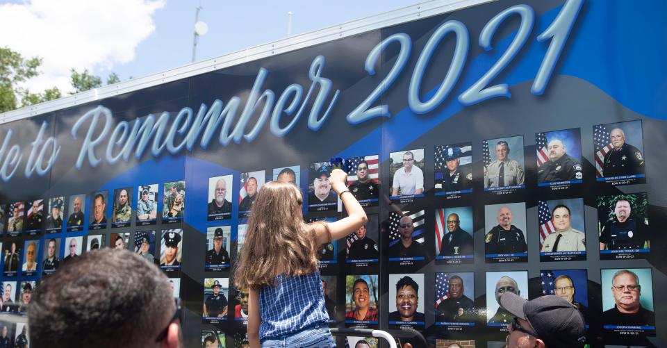 A flower is placed on a portrait of fallen Lee County Sheriff's Sgt. Steven Mazzotta at the Beyond the Call of Duty-Ride to Remember trailer wall at the Lee County Sheriff's Office on Monday, July 4, 2022, in Florida. Mazzotta died of complications of COVID-19. The Officer Down Memorial Page says more than 600 law enforcement officers have died of COVID-19. The End of Watch Ride started in Spokane, Washington, on June 1 is traveling 79 days across the United States making tribute stops at hundreds of law enforcement agencies to honor fallen law enforcement officers.