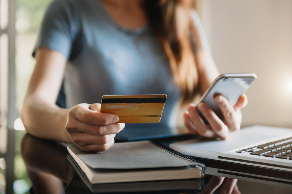 woman holding a credit card and a smartphone