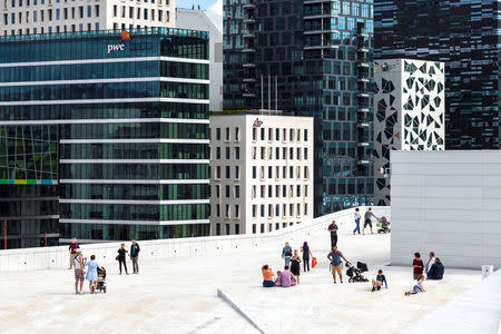 People stand on the roof of the Opera House, with buildings of The Barcode Project in the background, in Oslo, Norway August 2013. Svein Nordrum/NTB Scanpix/via REUTERS