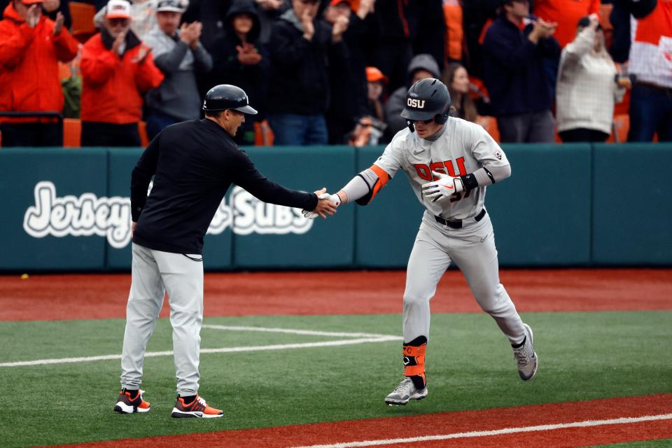 Jun 12, 2022; Corvallis, OR, USA; Oregon State Beavers infielder Travis Bazzana (37) is congratulated by third base coach Ryan Gipson as he circles the bases after his home run in the 4th inning during Game 2 of a NCAA Super Regional game at Coleman Field. Mandatory Credit: Soobum Im-USA TODAY Sports