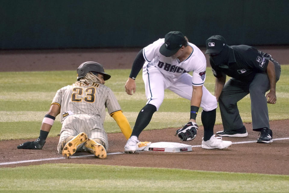 San Diego Padres' Fernando Tatis Jr. (23) dives into third base under a tag by Arizona Diamondbacks third baseman Andy Young in the fourth inning during a baseball game, Friday, Aug 14, 2020, in Phoenix. (AP Photo/Rick Scuteri)