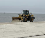 A tractor cleans Harrison County Beaches in Pass Christian, Miss., before a winter storm comes on Tuesday, Nov. 29, 2022. (Hunter Dawkins/The Gazebo Gazette via AP)