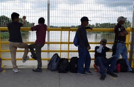 Migrants queue to request humanitarian visas to enter Mexico at the Rodolfo Robles international border crossing bridge, that connects Tecun Uman, Guatemala with Ciudad Hidalgo, Mexico, as seen from Ciudad Hidalgo