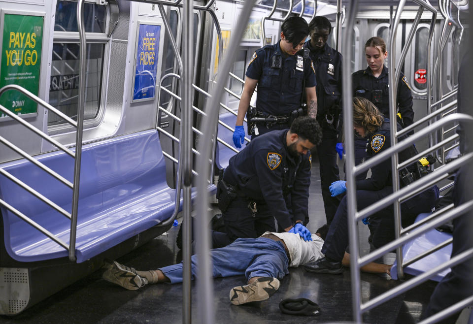 New York police officers administer CPR to Jordan Neely, at the scene where a fight was reported on a subway train, in New York, Monday, May 1, 2023. Neeley, suffering an apparent mental health episode aboard a New York City subway died on Monday after being placed in a headlock by a fellow rider, according to police officials and video of the encounter. (Paul Martinka via AP)