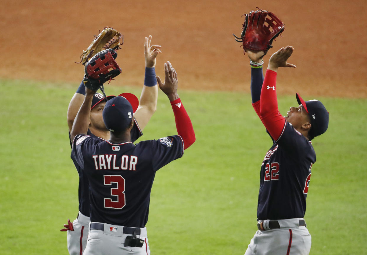 HOUSTON, TEXAS - OCTOBER 23:  Juan Soto #22, Michael A. Taylor #3 and Gerardo Parra #88 of the Washington Nationals celebrate their 12-3 win over the Houston Astros in Game Two of the 2019 World Series at Minute Maid Park on October 23, 2019 in Houston, Texas. (Photo by Tim Warner/Getty Images)