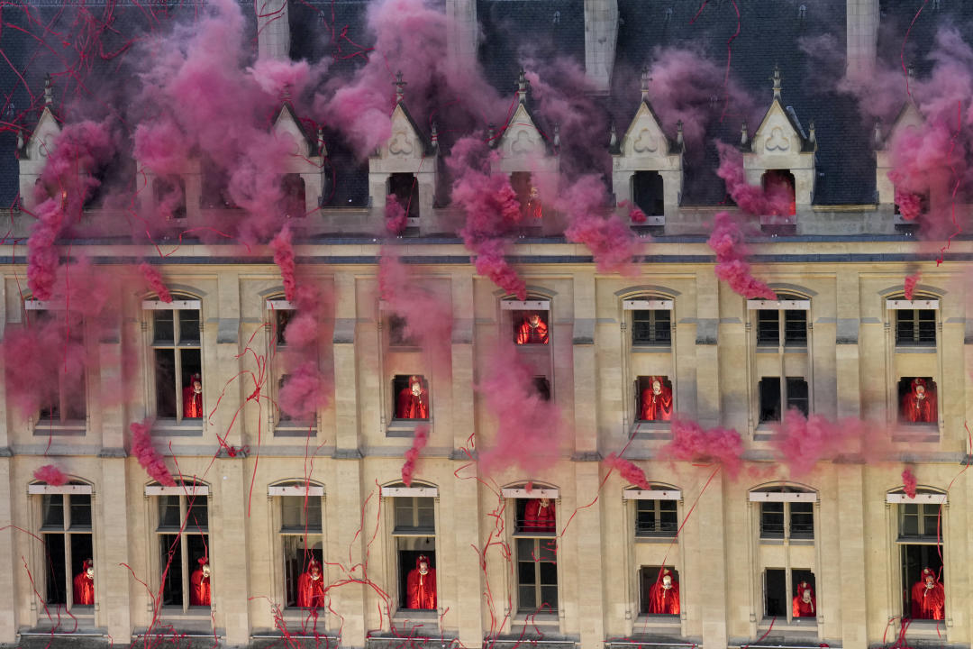 TOPSHOT - Smoke billows near windows as performers participate in the opening ceremony of the Paris 2024 Olympic Games in Paris on July 26, 2024. (Photo by Bernat Armangue / POOL / AFP) (Photo by BERNAT ARMANGUE/POOL/AFP via Getty Images)