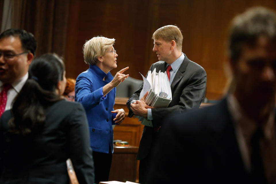 U.S. Senator Elizabeth Warren (D-MA) (L) talks with U.S. Consumer Financial Protection Bureau Director Richard Cordray (R) after he testified about Wall Street reform before a Senate Banking Committee hearing on Capitol Hill in Washington September 9, 2014. REUTERS/Jonathan Ernst    (UNITED STATES - Tags: POLITICS BUSINESS)