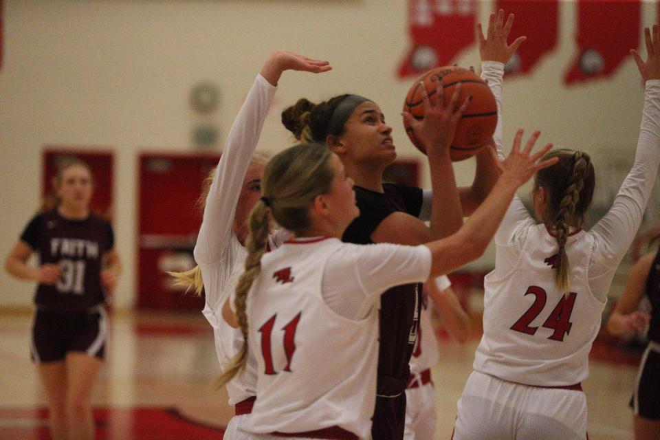 Faith Christian sophomore Maya Layton (center) attempts to score over the double team of Twin Lakes juniors Addie Bowsman (left) and Chloe Lucas (right) during the Twin Lakes Holiday Tournament on Wednesday, Dec. 27, 2023.