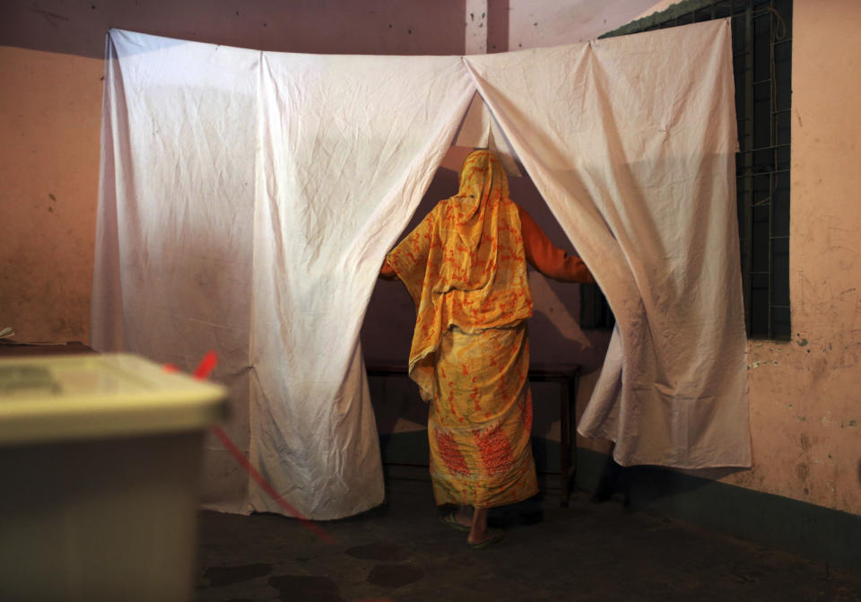 A Bangladeshi woman enters into a covered corner of a room to cast her vote, at a polling station in Dhaka, Bangladesh, Sunday, Jan. 5, 2014. Police in Bangladesh fired at protesters and more than 100 polling stations were torched in Sunday's general elections marred by violence and a boycott by the opposition, which dismissed the polls as a farce. (AP Photo/A.M. Ahad)