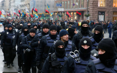 Police officers escort supporters of former Georgian President Mikheil Saakashvili as they march through the city centre during a rally in Kiev, Ukraine December 10, 2017. REUTERS/Gleb Garanich