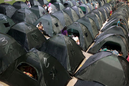 People rest in tents set up at the municipal coliseum after the Colombian government ordered the evacuation of residents living along the Cauca river, as construction problems at a hydroelectric dam prompted fears of massive flooding, in Valdivia, Colombia May 17, 2018. REUTERS/Fredy Builes