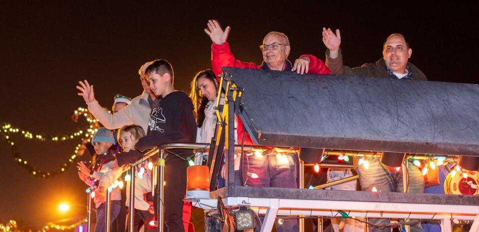 Visalia Vice Mayor Brian Poochigian, right, Mayor Steve Nelson other council members and their families wave to the crowd during the annual Candy Cane Lane Parade in Downtown Visalia on Monday, November 29, 2021.