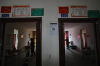 Ethnic minority Yi women stand inside their new apartment houses built by the Chinese government in Yuexi county, southwest China's Sichuan province on Sept. 11, 2020. Communist Party Xi Jinping’s smiling visage looks down from the walls of virtually every home inhabited by members of the Yi minority group in a remote corner of China’s Sichuan province. Xi has replaced former leader Mao Zedong for pride of place in new brick and concrete homes built to replace crumbling traditional structures in Sichuan’s Liangshan Yi Autonomous Prefecture, which his home to about 2 million members of the group. (AP Photo/Andy Wong)