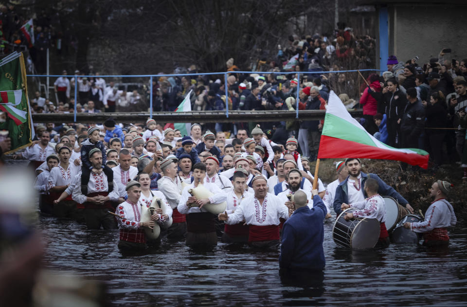 Men play bagpipes and drums as they form a procession into the cold Tundzha River to celebrate Epiphany, in the town of Kalofer, Bulgaria, Saturday, Jan. 6, 2024. The legend goes that the person who retrieves the wooden cross from the river will be freed from evil spirits and will be healthy throughout the year. Epiphany marks the end of the 12 days of Christmas, but not all Orthodox Christian churches celebrate it on the same day. (AP Photo/Valentina Petrova)