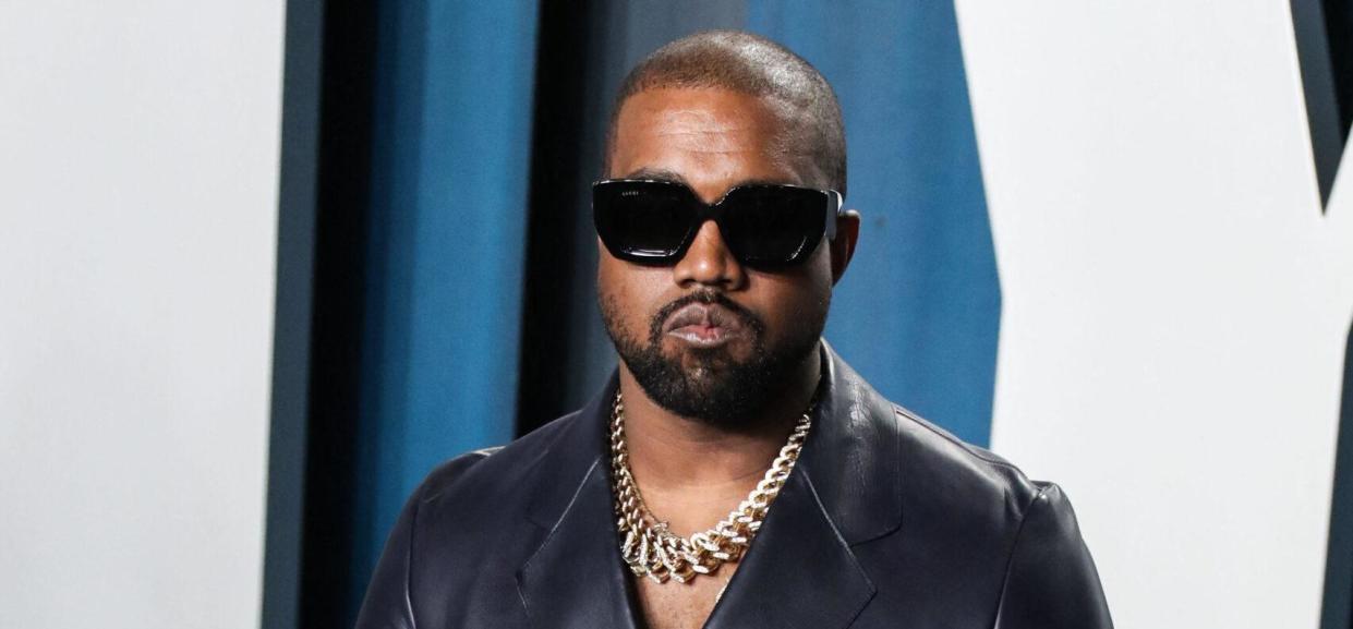 Kanye West wearing a black suit