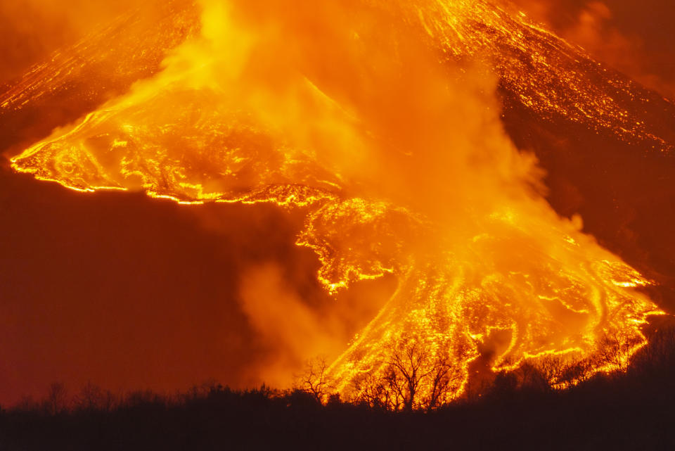 A fiery river of glowing lava flows on the north-east side of the Mt Etna volcano near Milo, Sicily, Wednesday night, Feb. 24, 2021. Europe's most active volcano has been steadily erupting since last week, belching smoke, ash, and fountains of red-hot lava. (AP Photo/Salvatore Allegra)