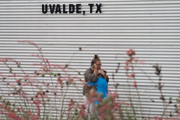 PHOTO: A woman cries and hugs a young girl while on the phone outside the Willie de Leon Civic Center where grief counseling will be offered in Uvalde, Texas, May 24, 2022. (Allison Dinner/AFP via Getty Images, FILE)