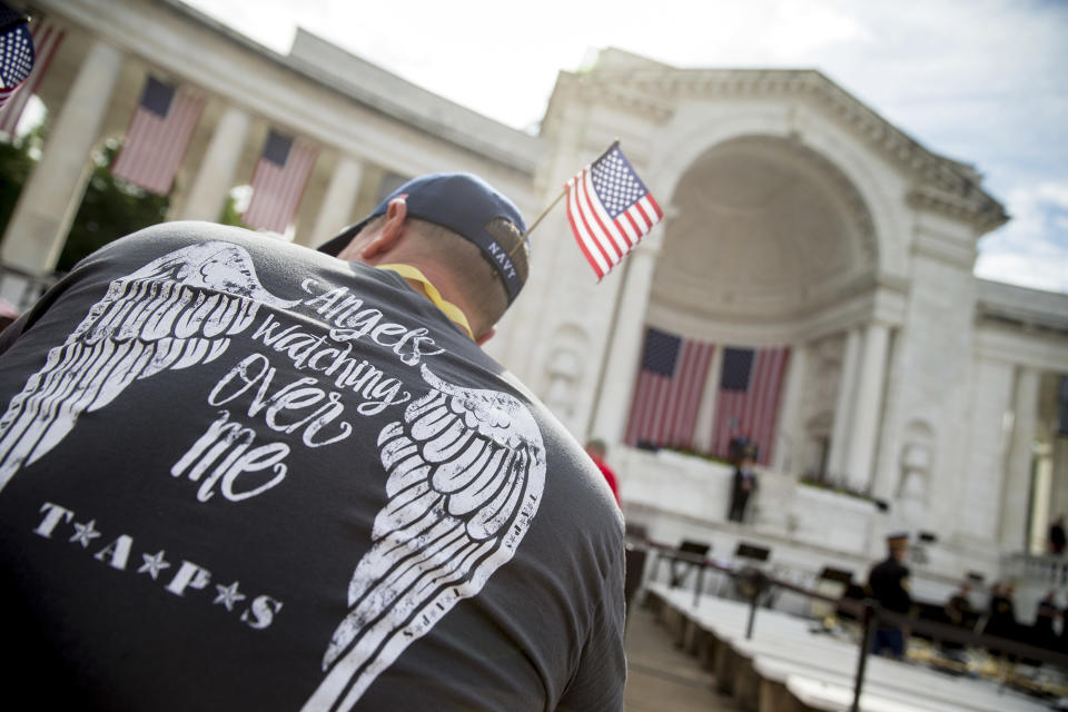 <p>Chris Payne of Kalama, Wash. wears a Tragedy Assistance Program for Survivors (TAPS) shirt depicting wings on his back as he and other guests wait for President Obama to speak at the Memorial Amphitheater of Arlington National Cemetery on Monday, May 30, 2016, during a Memorial Day ceremony. Payne is attending in memory of Army Spc. Eric D. King, who was killed in Baghdad in 2006. (Photo: Andrew Harnik/AP) </p>