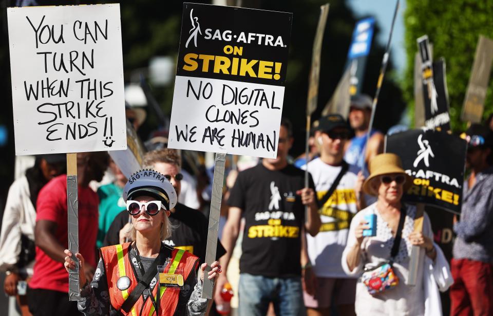 SAG-AFTRA member Cari Ciotti holds a sign that reads, "no digital clones we are human" on Oct. 16, 2023, in Los Angeles.