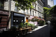 Chairs and tables of a cafe are stacked up in a street of the Marais district, in Paris, Monday, June 1, 2020. Parisians who have been cooped up for months with take-out food and coffee will be able to savor their steaks tartare in the fresh air and cobbled streets of the City of Light once more -- albeit in smaller numbers. (AP Photo/Thibault Camus)