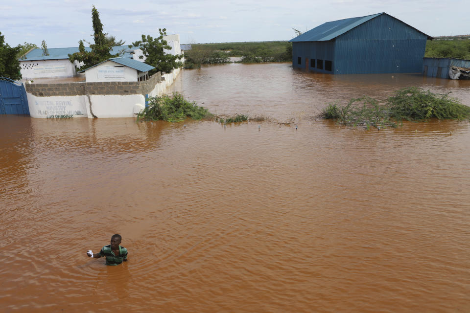 A man swims from a submerged church compound, after the River Tana broke its banks following heavy rains at Mororo, border of Tana River and Garissa counties, North Eastern Kenya, Sunday, April. 28, 2024. Heavy rains pounding different parts of Kenya have led to dozens of deaths and the displacement of tens of thousands of people, according to the U.N. (AP Photo/Andrew Kasuku)