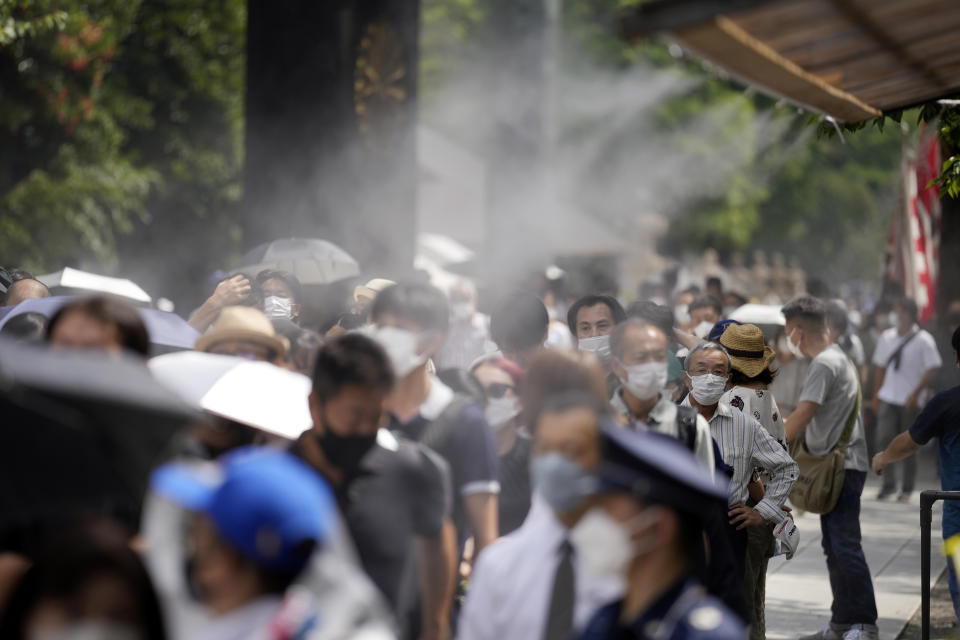 People queue to pay respects to the war dead at Yasukuni Shrine Monday, Aug. 15, 2022, in Tokyo. Japan marked the 77th anniversary of its World War II defeat Monday. (AP Photo/Eugene Hoshiko)