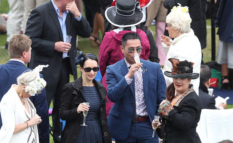 <p>Pictured: Punters brave wild weather as Melbourne Cup festivities get underway</p>