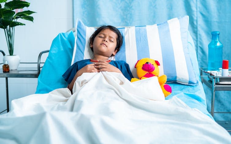 Sick child laying in hospital bed.