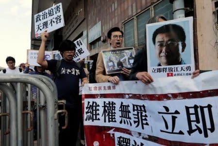 FILE PHOTO: Pro-democracy demonstrators hold up portraits of Chinese disbarred lawyer Jiang Tianyong, demanding his release, during a demonstration outside the Chinese liaison office in Hong Kong, China December 23, 2016. REUTERS/Tyrone Siu