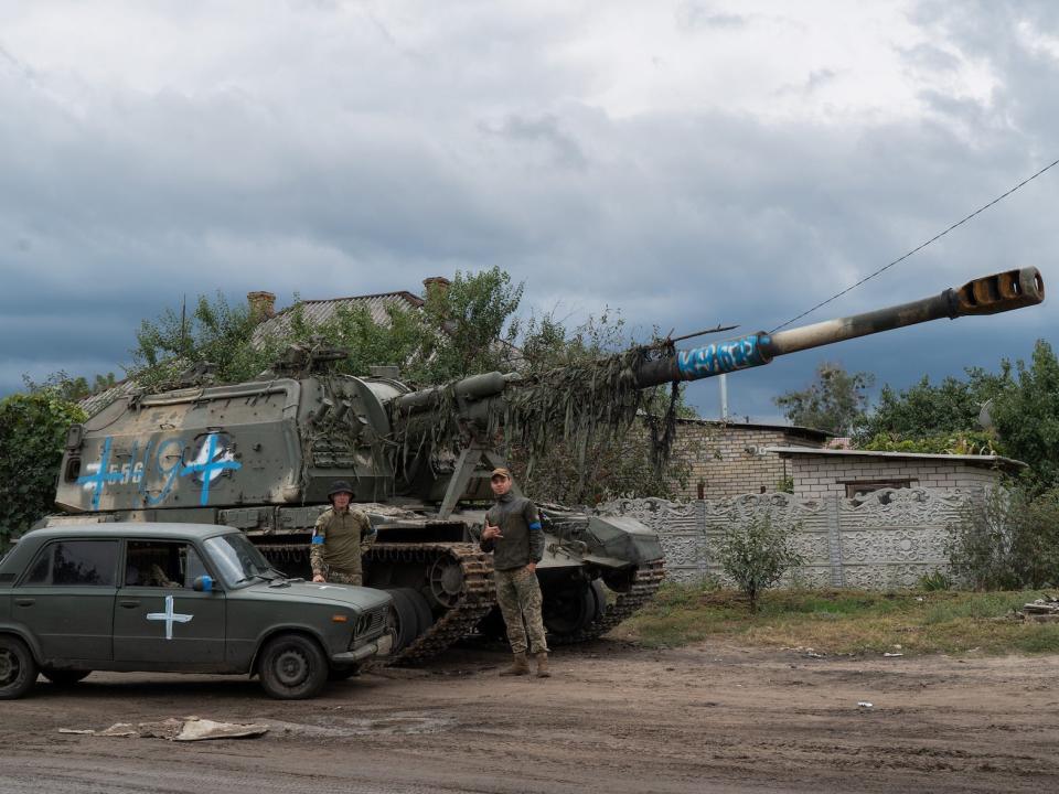 Ukrainian troops with captured Russian self-propelled artillery gun