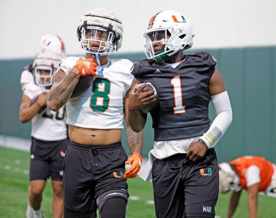 Miami Hurricanes quarterback Cam Ward (1) and tight end Elijah Arroyo (8) run between practice drills at the Carol Soffer Indoor Practice Facility in Coral Gables, Florida on Wednesday, March 6, 2024.