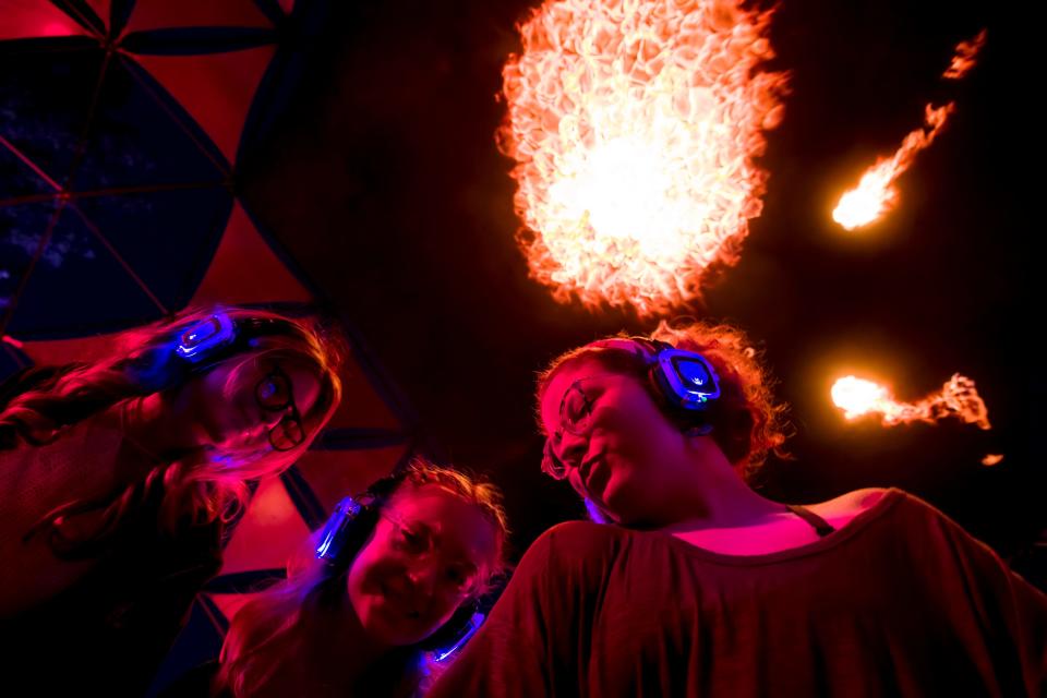 From right, Julie Bailey, Katie Burns and Dani Debotton dance under a fire dome within the Silent Disco at the 2022 Mempho Music Festival at Memphis Botanic Garden on Friday, Sept. 30, 2022.