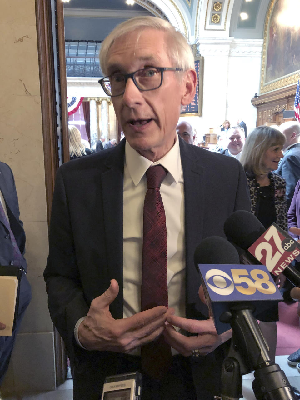 FILE--In this Tuesday, April 9, 2019, file photo, Wisconsin Democratic Gov. Tony Evers talks to reporters during a lame-duck legislative session in Madison, Wisconsin. Flying a gay pride rainbow flag over the Wisconsin state Capitol for the first time is drawing backlash from a conservative Republican lawmaker who said it was divisive. The flag flap Friday erupted after Evers ordered the raising of the flag to recognize June as "Pride Month." The move drew a fast backlash from state Rep. Scott Allen, who tweeted, "Is this any more appropriate than erecting the Christian flag over the Capitol?" Democrats praised the raising of the flag. (AP Photo/Scott Bauer, File)